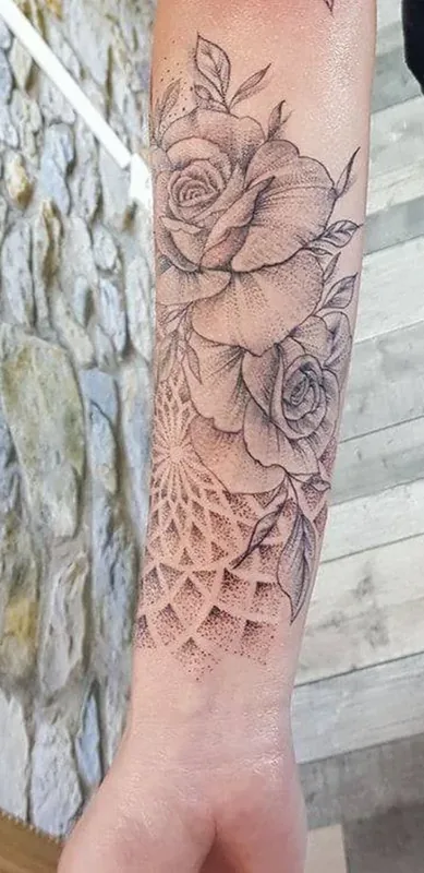 Rose et motifs ornementaux tatoués sur l’avant-bras par Yan