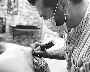 Yan réalisant un tatouage dans son studio près de Pau